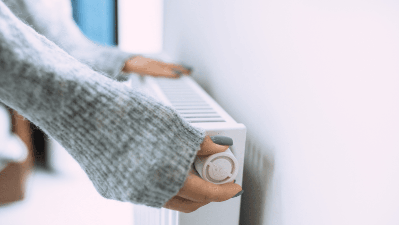 Femme en train de régler son radiateur